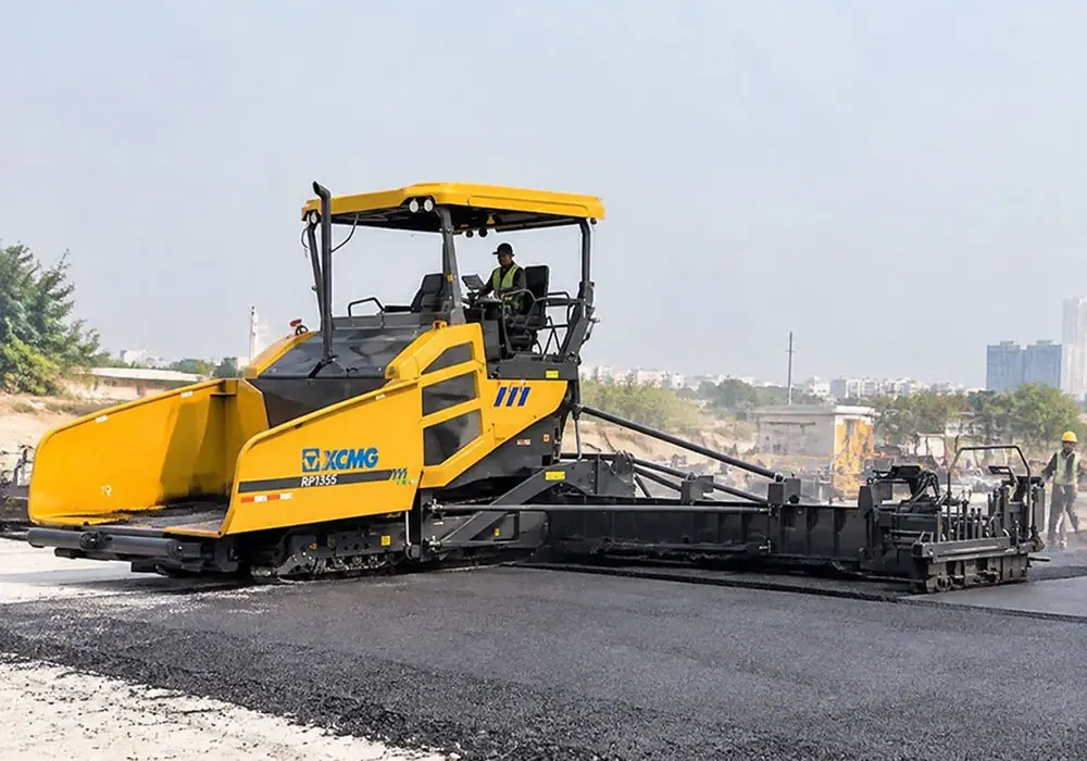 Side view of an XCMG RP1355 tracked asphalt paver laying a smooth base layer, highlighting its 12.5m paving width and mechanical screed system.